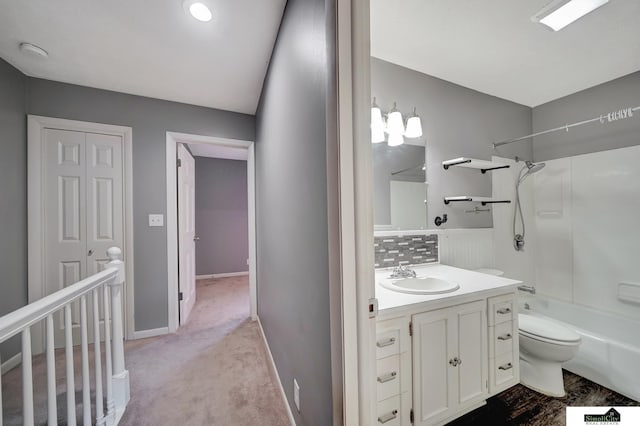 full bathroom featuring toilet, vanity, backsplash, and shower / bath combination