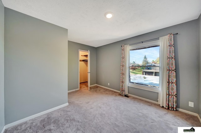 carpeted empty room featuring a textured ceiling