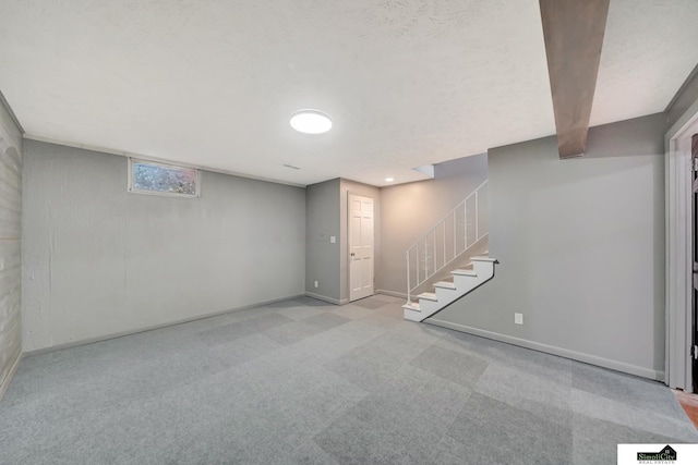 basement with a textured ceiling and light colored carpet