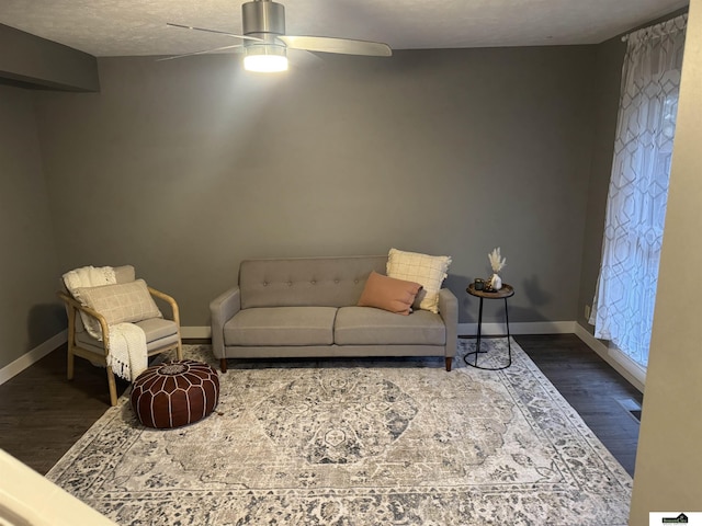 living room featuring ceiling fan, a textured ceiling, and hardwood / wood-style flooring