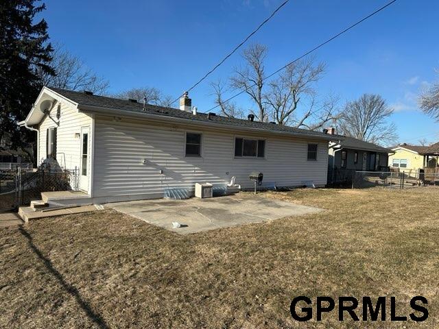 rear view of house featuring a yard and a patio