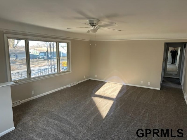 empty room featuring crown molding, dark colored carpet, a healthy amount of sunlight, and ceiling fan