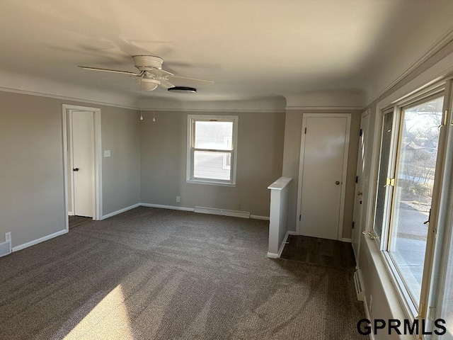 interior space with ceiling fan, plenty of natural light, and dark colored carpet