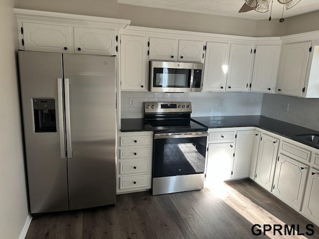 kitchen featuring stainless steel appliances, backsplash, dark wood-type flooring, white cabinets, and sink