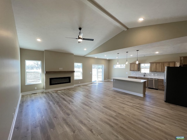 kitchen with light wood-style floors, open floor plan, light countertops, appliances with stainless steel finishes, and a center island