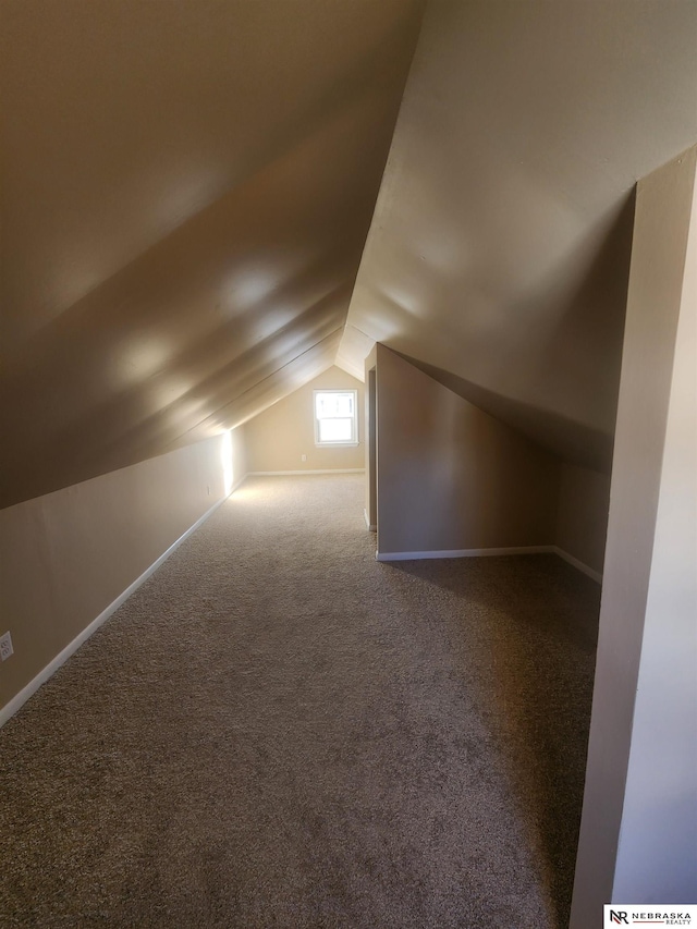 bonus room with vaulted ceiling and carpet floors