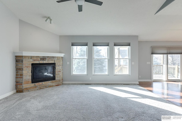 unfurnished living room with ceiling fan, lofted ceiling, light colored carpet, and a fireplace