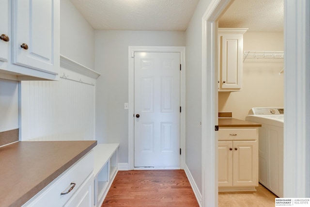 mudroom with washer / dryer, light hardwood / wood-style flooring, and a textured ceiling