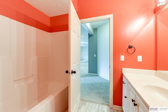 bathroom with vanity, wood-type flooring, and a textured ceiling