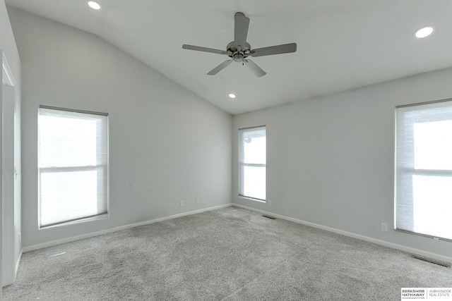 empty room featuring ceiling fan, vaulted ceiling, and light carpet