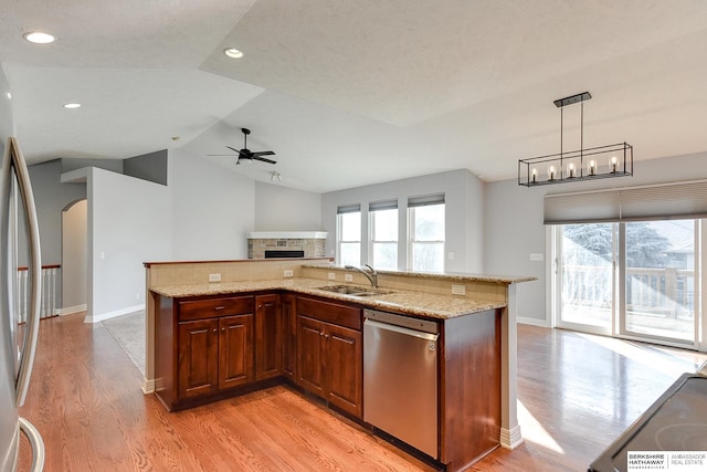 kitchen featuring hanging light fixtures, light stone countertops, sink, and appliances with stainless steel finishes