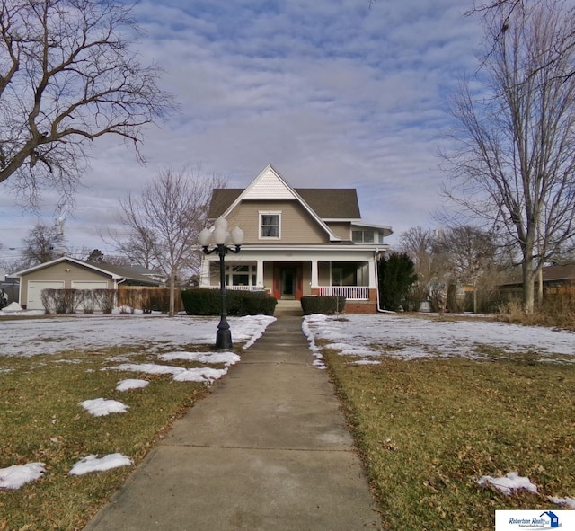 view of front of home featuring a garage, an outdoor structure, a front lawn, and a porch