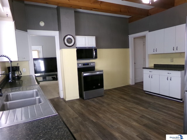 kitchen with beam ceiling, electric stove, a sink, dark wood-style floors, and white cabinets