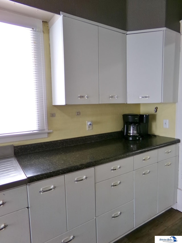 kitchen with dark countertops, white cabinets, and dark wood finished floors