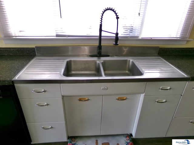 kitchen featuring dark countertops and white cabinets