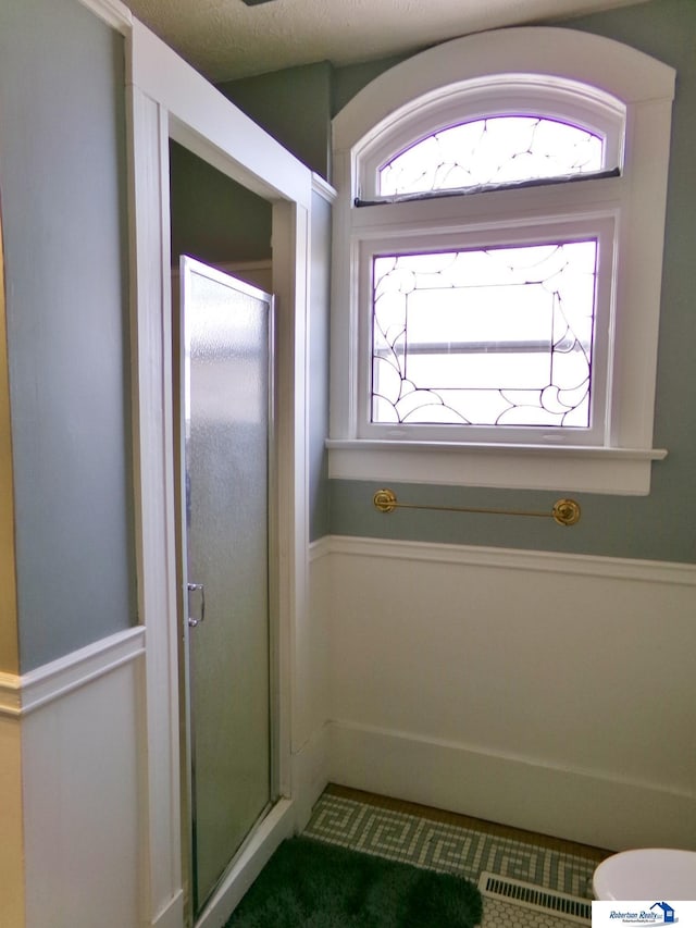 full bathroom with visible vents, a textured ceiling, and a stall shower