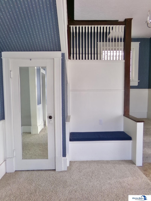 interior space featuring carpet floors and wallpapered walls