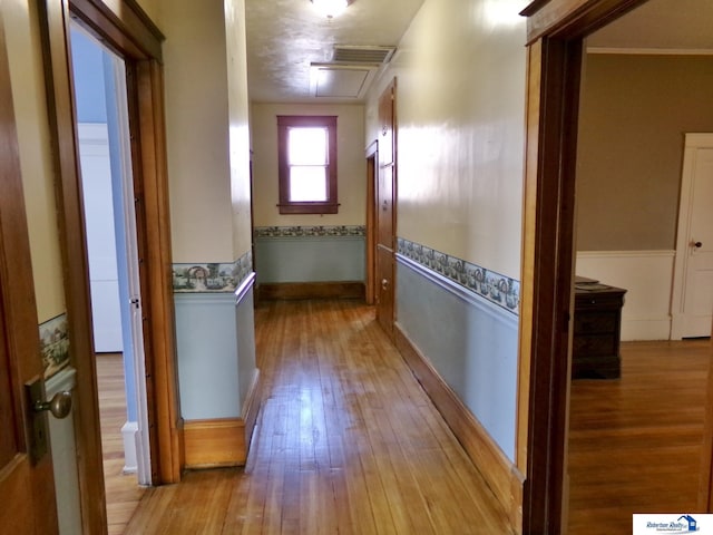 hallway featuring wainscoting and hardwood / wood-style flooring