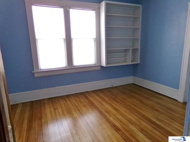 empty room featuring baseboards and wood-type flooring