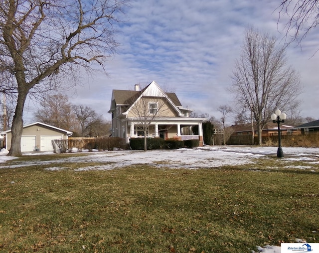 view of front facade featuring a chimney, a detached garage, a yard, and an outdoor structure