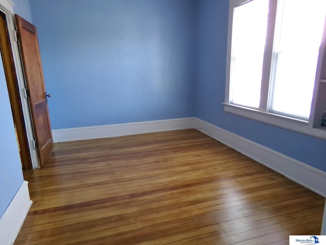 spare room featuring light wood-type flooring and baseboards