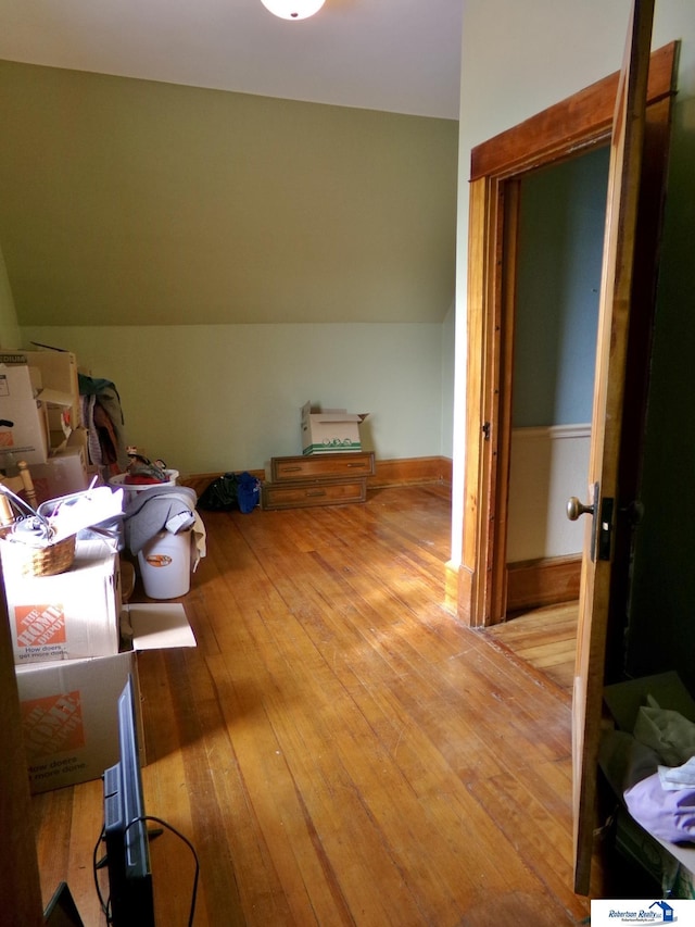 interior space with hardwood / wood-style flooring and vaulted ceiling