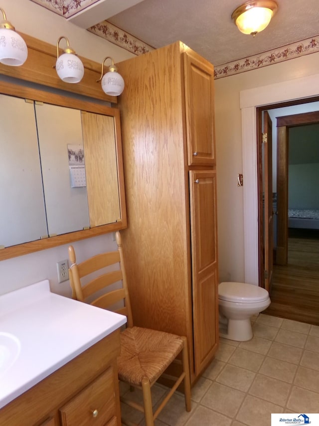 bathroom featuring vanity, tile patterned floors, and toilet