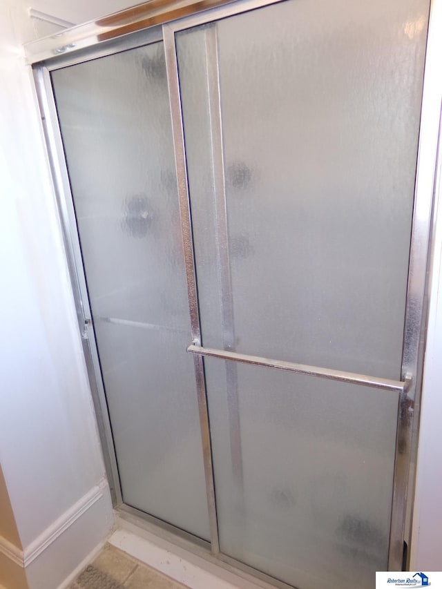 full bathroom featuring tile patterned flooring and a stall shower