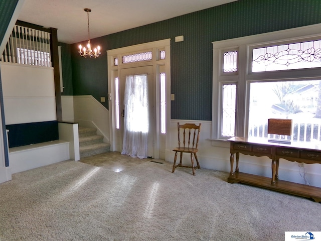 carpeted foyer entrance with wallpapered walls, stairway, and a healthy amount of sunlight