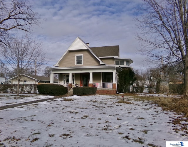 view of front facade featuring a porch and a chimney