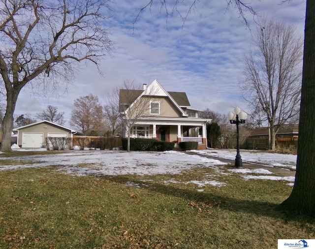 view of front of house with an outbuilding, a lawn, a detached garage, covered porch, and a chimney