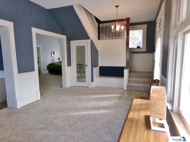 interior space with wallpapered walls, stairs, a wainscoted wall, and a chandelier