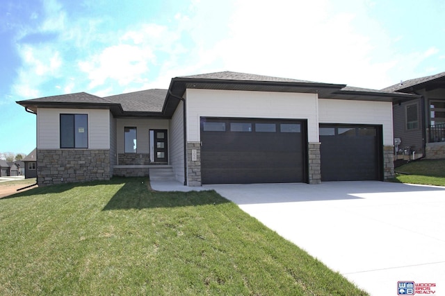 prairie-style home featuring a front lawn and a garage