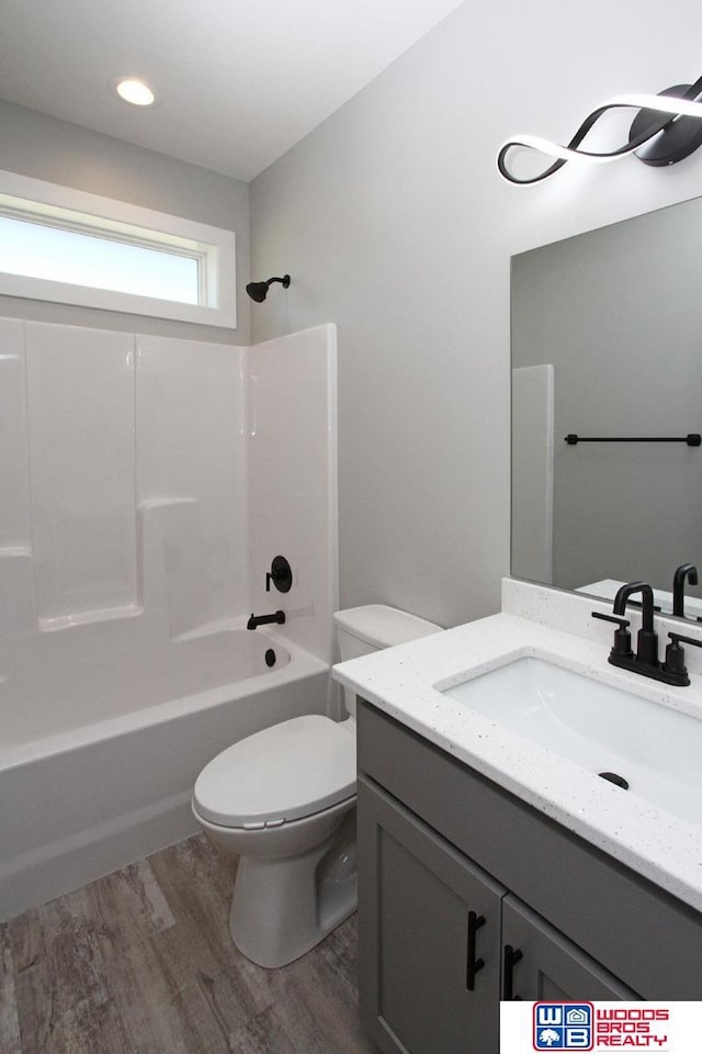 full bathroom featuring toilet, vanity, bathing tub / shower combination, and hardwood / wood-style floors