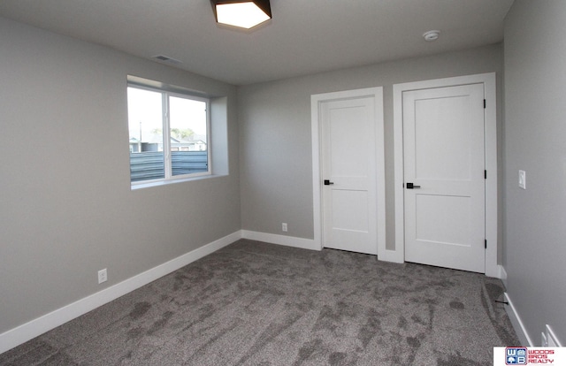 unfurnished bedroom featuring dark carpet