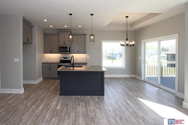 kitchen featuring decorative light fixtures, appliances with stainless steel finishes, sink, and gray cabinetry