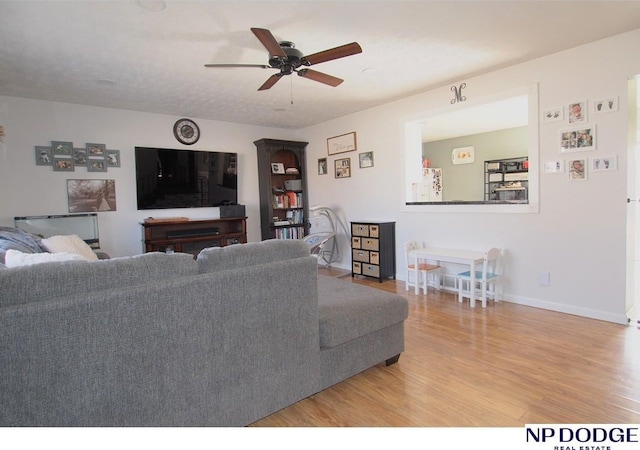 living room with wood-type flooring and ceiling fan