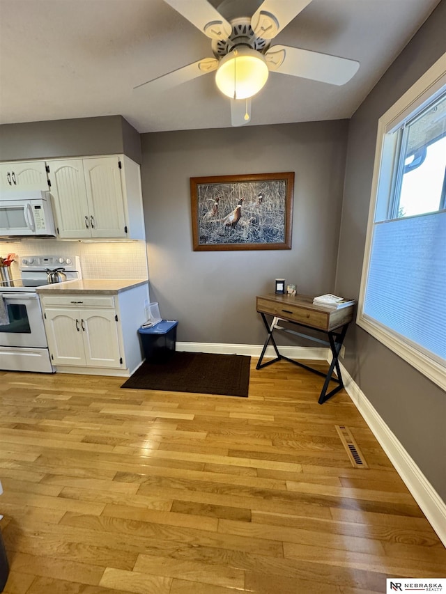 kitchen featuring decorative backsplash, light hardwood / wood-style flooring, white cabinets, and white appliances