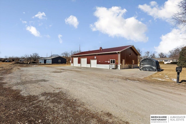 exterior space featuring a garage and an outbuilding