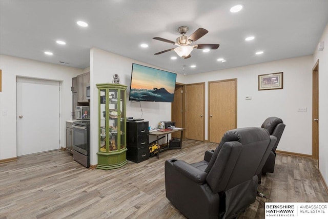 living room with light hardwood / wood-style floors and ceiling fan