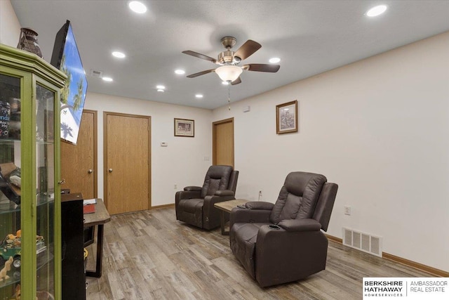 sitting room with ceiling fan and light wood-type flooring