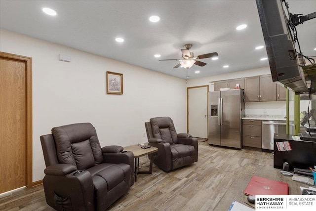 living room featuring ceiling fan and light hardwood / wood-style flooring