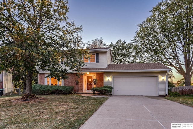 view of property featuring a garage and a lawn