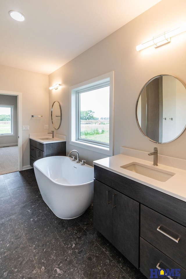 bathroom with a bathtub, plenty of natural light, and vanity