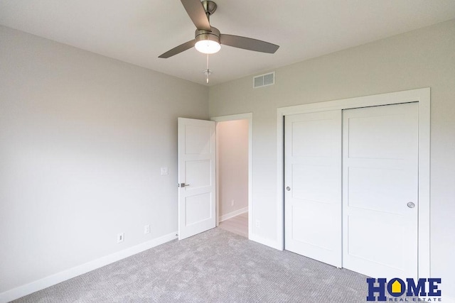 unfurnished bedroom with ceiling fan, a closet, and light carpet