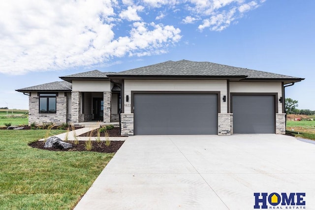 prairie-style home featuring a front yard and a garage