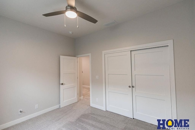 unfurnished bedroom with ceiling fan, a closet, and light carpet