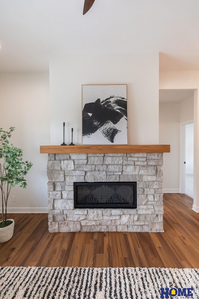 room details featuring ceiling fan, a fireplace, and wood-type flooring