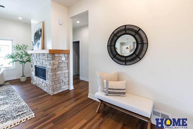 interior space with dark hardwood / wood-style flooring and a stone fireplace