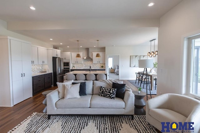 living room with sink, dark hardwood / wood-style flooring, and an inviting chandelier